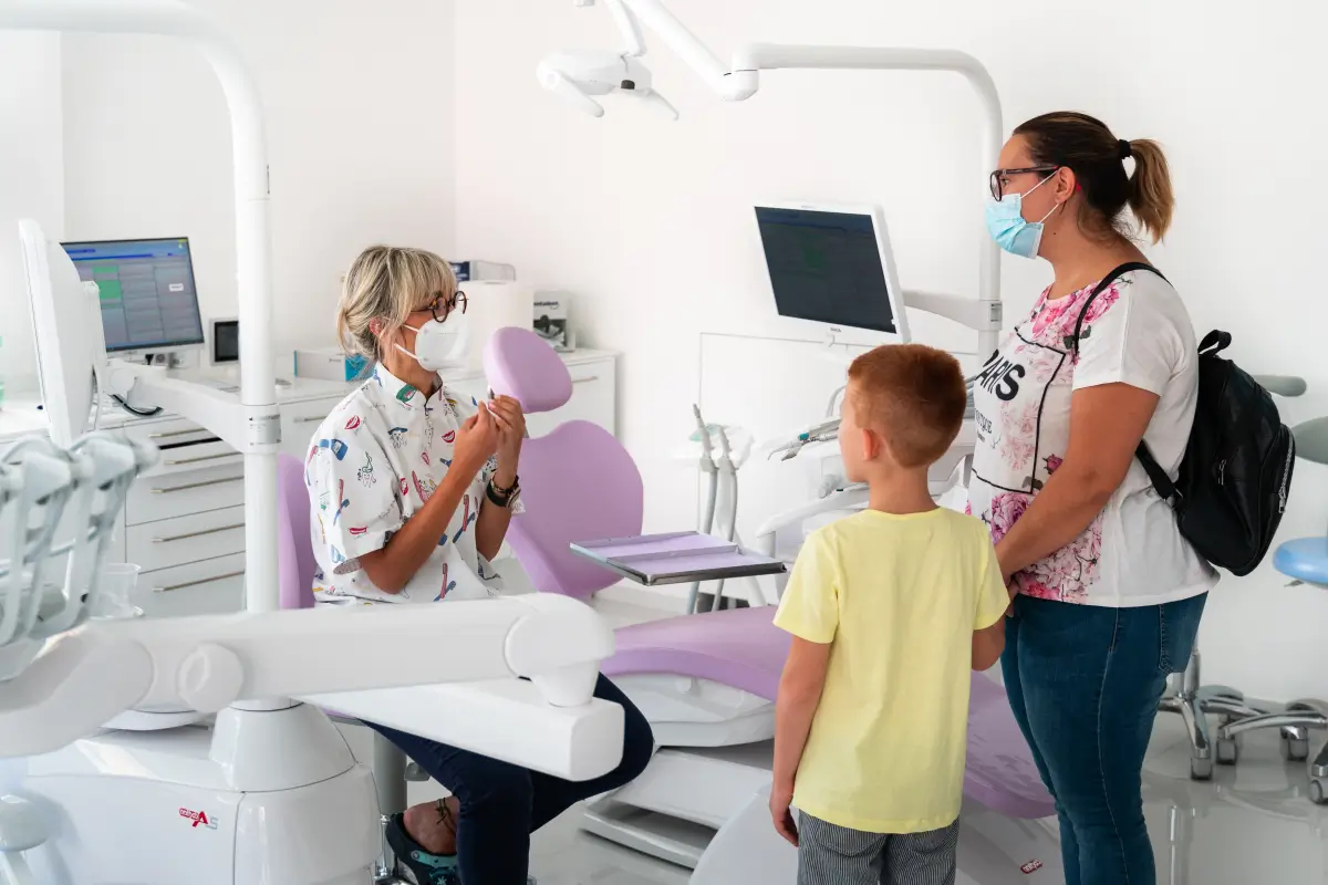 il mio impegno per la comunita (1) La Dottoressa Alice Cutrera Dentista pediatrica nel suo studio riceve una mamma con il suo bambino per una prima visita